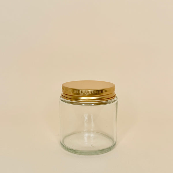 Envase de vidrio transparente C/tapa dorada 100 ML