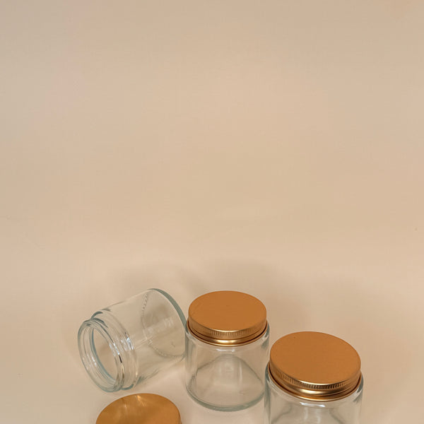 Envase de vidrio transparente C/tapa dorada 100 ML