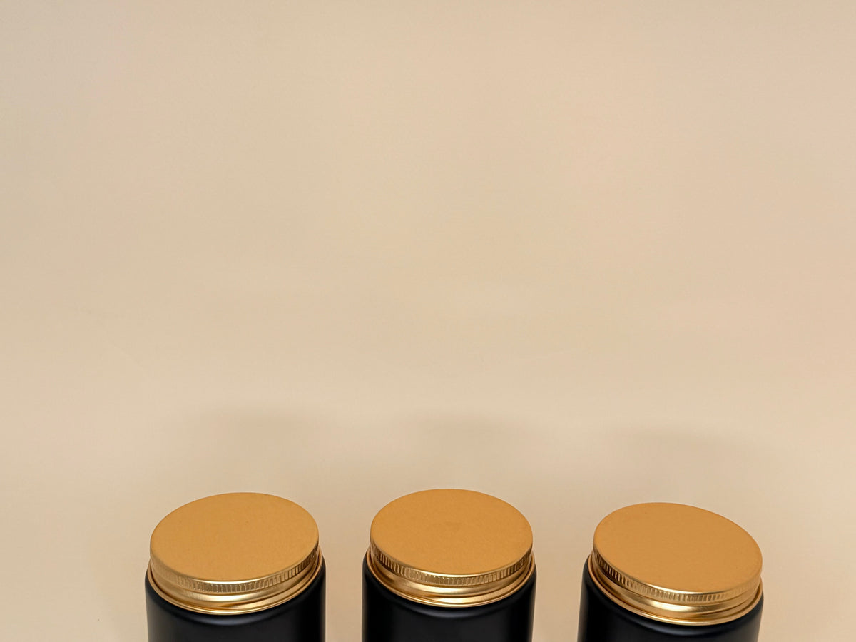 Envase de vidrio negro con tapa dorada 100ML